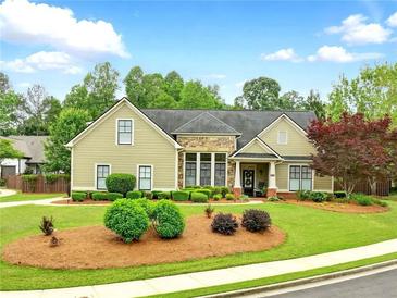 Charming single Gathering home with manicured front yard and a combination of siding and stone exterior finishes at 3174 Piney Woods Cir, Buford, GA 30519