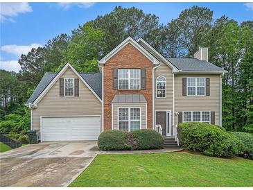 Traditional two-story home featuring brick and siding with a well-manicured front lawn and an attached two-car garage at 3885 Weeping Willow Ln, Loganville, GA 30052