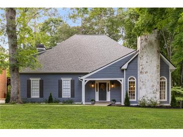 Charming home featuring a stone chimney, blue siding, and a well-manicured lawn at 8260 Overview Ct, Roswell, GA 30076