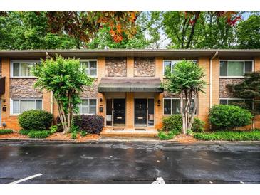 Charming brick townhome featuring a cozy entrance, stone accents and landscaped greenery, perfect for comfortable living at 120 Biscayne Nw Dr # C13, Atlanta, GA 30309