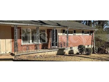 Traditional home with a welcoming front porch framed by decorative iron railings and brick accents at 1911 Rosewood Rd, Decatur, GA 30032