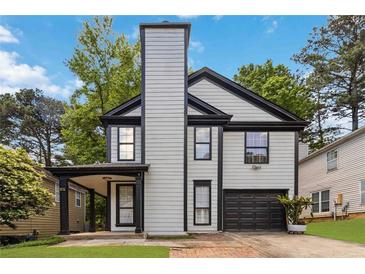 Charming two-story home featuring light gray siding, a tall chimney, and a single-car garage at 1050 Hampton Hill Ct, Lawrenceville, GA 30044