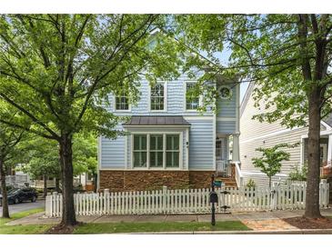 Charming two-story home with light blue siding, stone accents, and a white picket fence at 1560 Gilstrap Nw Ln, Atlanta, GA 30318