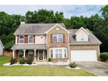 Charming two-story home featuring a manicured lawn, brick accents, and attached two car garage at 2086 Grant Ave, Mcdonough, GA 30252