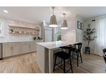 Bright kitchen with stainless steel appliances, center island with seating, and stylish pendant lighting at 2840 Alpine Rd, Atlanta, GA 30305