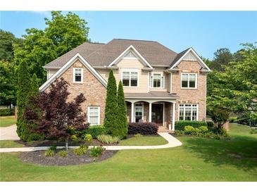 Charming brick home with a well-manicured lawn and inviting front porch at 440 Scott Farm Dr, Powder Springs, GA 30127