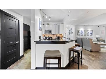 A charming kitchen featuring a breakfast bar, stainless steel appliances, and elegant modern finishes at 1250 Parkwood Se Cir # 3001, Atlanta, GA 30339