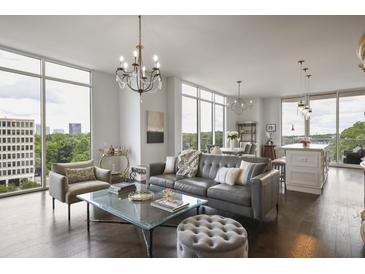 Bright, open living room with hardwood floors, modern furniture, and large windows with city views at 1820 Peachtree St # 614, Atlanta, GA 30309