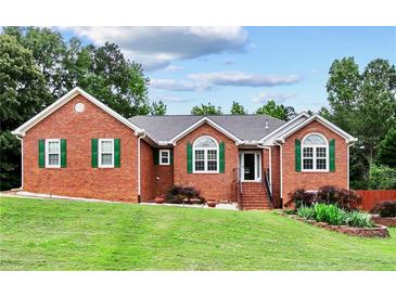 Charming single-story brick home with well-manicured lawn, green shutters, and a welcoming entrance at 124 Crown Walk, Mcdonough, GA 30253