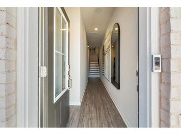 Inviting foyer featuring light wood floors, a staircase, and modern decorative mirror at 209 Maycrest Path, Tucker, GA 30084