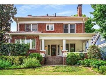 Charming two-story brick home featuring a welcoming front porch and well-manicured landscaping at 1095 Saint Charles Ne Pl, Atlanta, GA 30306