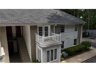 A multi-level apartment building featuring a charming white balcony, stairs, and a well-maintained exterior at 1212 Utoy Springs Rd # 46, Atlanta, GA 30331