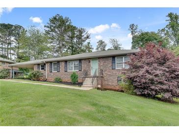 Charming brick home with a well-manicured lawn and mature landscaping at 2653 Elkhart Sw Cir, Marietta, GA 30064