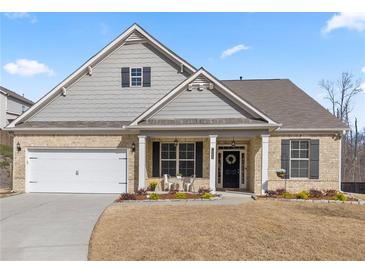 Charming single-Gathering home with brick and siding, a two-car garage, and a beautifully landscaped front yard at 7995 Brewton Creek Dr, Cumming, GA 30028