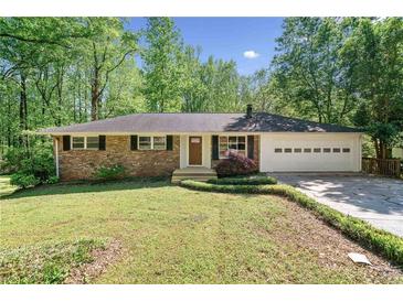 Charming one-story brick home with a well-manicured lawn and mature trees, creating a welcoming curb appeal at 1131 Mayfield Dr, Decatur, GA 30033