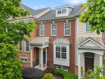 Charming townhome with brick facade, covered porch, and manicured landscaping, creating an inviting curb appeal at 4879 Seldon Se Way, Smyrna, GA 30080