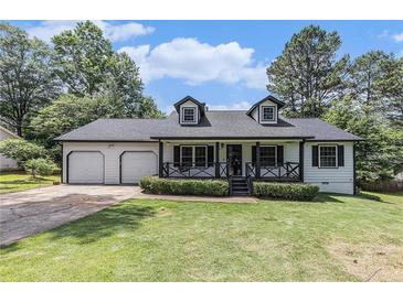 Charming home with a well-manicured lawn, two-car garage, dormer windows and inviting front porch at 5406 Jamestowne Dr, Powder Springs, GA 30127