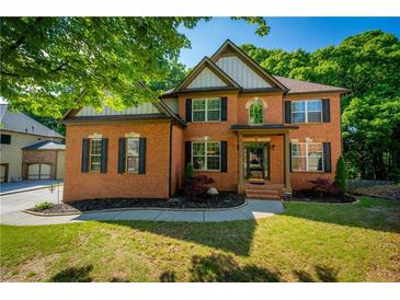 Traditional brick home with manicured front lawn, black shutters, and mature trees at 1059 Verbena Way, Auburn, GA 30011