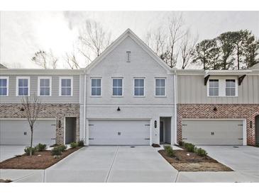 Modern townhome with a brick and siding exterior and an attached garage and concrete driveway at 4527 Moray Dr, Mableton, GA 30126