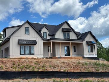Stunning new construction featuring board and batten siding, dark window trim, and a covered front porch at 1089 Mount Carmel Church Ln, Canton, GA 30114