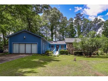 Charming single-story home with a large front yard and an attached two-car garage at 3739 Lake Carlton Rd, Loganville, GA 30052