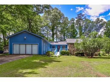 Charming blue home featuring a well-manicured lawn and an inviting entrance walkway at 3739 Lake Carlton Rd, Loganville, GA 30052