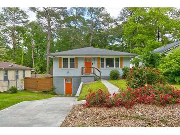 Charming bungalow with orange doors and shutters and landscaping at 569 Woods Nw Dr, Atlanta, GA 30318