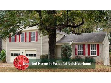 Charming two-story home featuring a well-maintained lawn, an attached two-car garage, and red shutters at 615 Barrington Way, Roswell, GA 30076