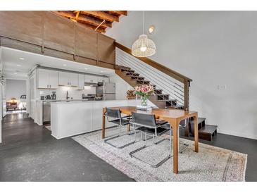 Bright dining area featuring a modern table with chairs, a stairway, and an adjacent sleek white kitchen at 510 Edgewood Ne Ave # 6, Atlanta, GA 30312