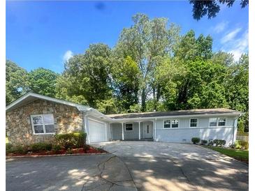 Charming single-story home featuring a stone facade, attached garage, and a spacious driveway at 2251 S Hairston Rd, Decatur, GA 30035