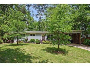 Charming single-story home with mature trees, lush lawn, and a covered parking area at 3018 Monterey Dr, Decatur, GA 30032