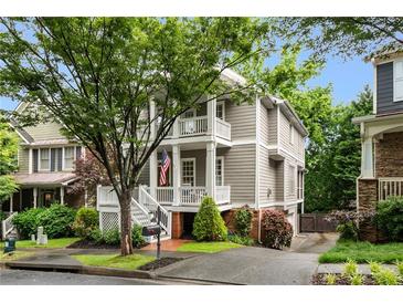 Charming two-story home featuring a welcoming front porch, mature tree, and lovely landscaping at 1626 Gilstrap Nw Ln, Atlanta, GA 30318