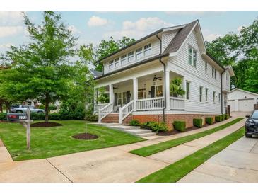 Beautiful two-story home featuring a welcoming front porch, pristine landscaping, and a private driveway leading to a detached garage at 172 Olympic Pl, Decatur, GA 30030