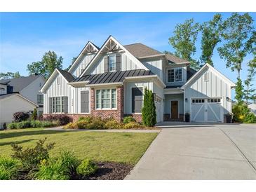 Charming two-story home featuring light blue siding, brick accents, and a well-manicured lawn at 2208 Sage Mountain Sw Ct, Marietta, GA 30064