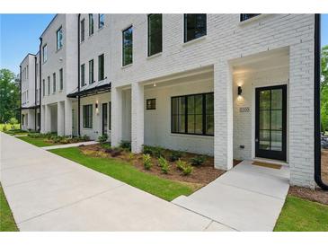 New townhouse exterior with white painted brick, black window trim, and manicured lawn at 2200 Carlton Ct # 6, Atlanta, GA 30318