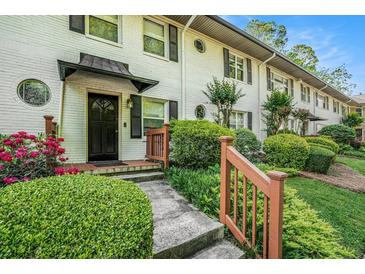 Charming townhouse with a brick facade, black shutters, and landscaped front yard at 2477 N Decatur Rd # A1, Decatur, GA 30033