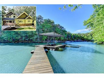 A dock with a lake house in the background, offering waterfront living and recreational opportunities on the serene lake at 975 Timber Lake Trl, Cumming, GA 30041