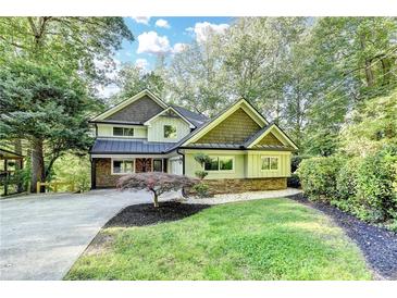 Charming home with beautiful landscaping, stone accents, and a lush, tree-filled yard at 975 Timber Lake Trl, Cumming, GA 30041
