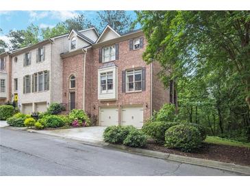 Brick townhome with two-car garage and manicured landscaping at 7249 Village Creek Trce, Atlanta, GA 30328