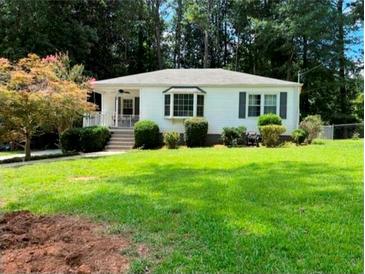 Charming single-story home with a well-maintained lawn and mature trees at 1038 Ralph Ne Rd, Atlanta, GA 30324