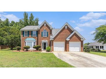 Charming two-story brick home with manicured lawn and attached two-car garage at 48 Savanna Ct, Powder Springs, GA 30127