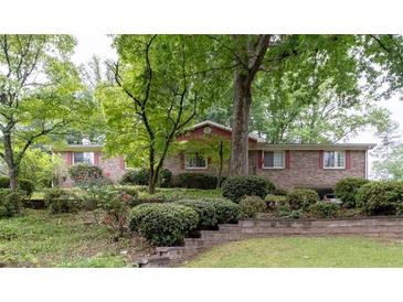 Charming brick home with mature trees and landscaping, offering a serene and inviting curb appeal at 1690 Cedar Grove Dr, Marietta, GA 30066