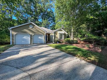 Charming single-story home with a two-car garage, landscaped front yard, and a driveway at 2160 Towne Manor Nw Dr, Kennesaw, GA 30144