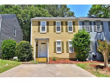 Charming two-story home with yellow siding, green shutters, and a well-manicured front yard at 4120 Buckley Woods Dr, Norcross, GA 30093