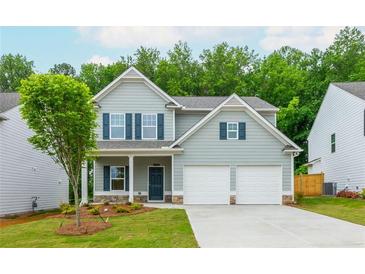 Charming two-story home with a well-manicured lawn, attached two car garage and stone accents at 174 Bloomfield Cir, Canton, GA 30114