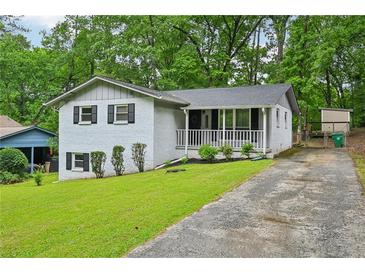 Charming exterior view of white painted home with inviting front porch and landscaped yard at 1118 Creekdale Dr, Clarkston, GA 30021