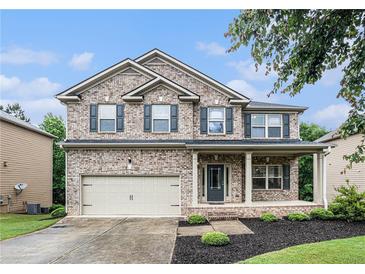 Charming two-story brick home featuring a covered front porch and well-manicured lawn at 4910 Bucknell Trce, Cumming, GA 30028