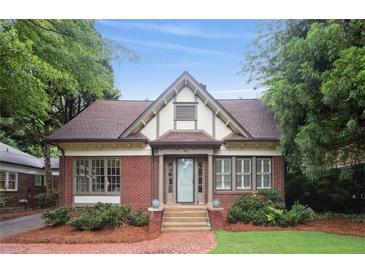 Charming Tudor home with brick facade, symmetrical windows, manicured landscaping and a tiled front walkway at 96 Dartmouth Ave, Avondale Estates, GA 30002