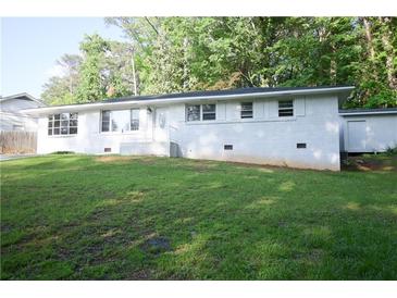 Charming white brick ranch-style home with lush front lawn and manicured landscaping at 345 Forest Valley Rd, Lawrenceville, GA 30046