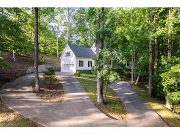 Charming two-story home with a manicured yard and a long driveway through a wooded area at 7240 Highbrook Cir, Cumming, GA 30041